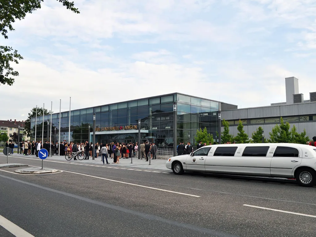 Weiße Stretchlimousine vor der Stadthalle.